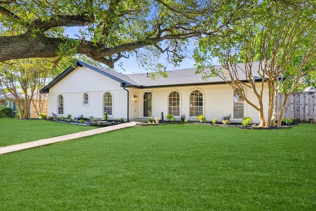 ranch-style home featuring brick siding and roof with shingles