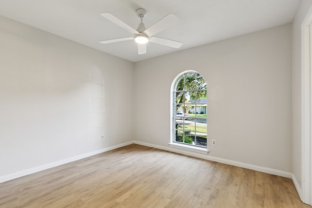 unfurnished room with light wood finished floors, baseboards, and ceiling fan