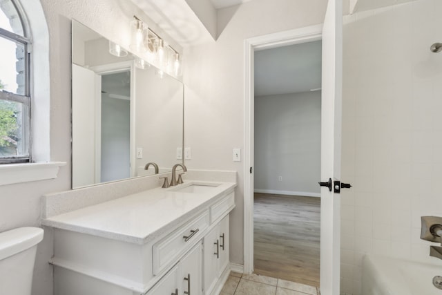 bathroom featuring toilet, vanity, tile patterned floors, and shower / tub combination