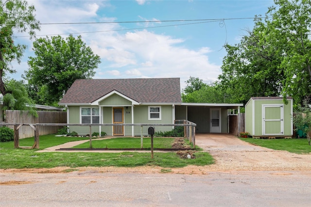 view of front of property with a storage shed, a shingled roof, driveway, an outbuilding, and an attached carport