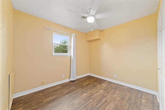 spare room featuring wood finished floors, baseboards, and ceiling fan