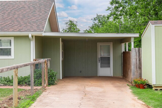 property entrance with roof with shingles and fence