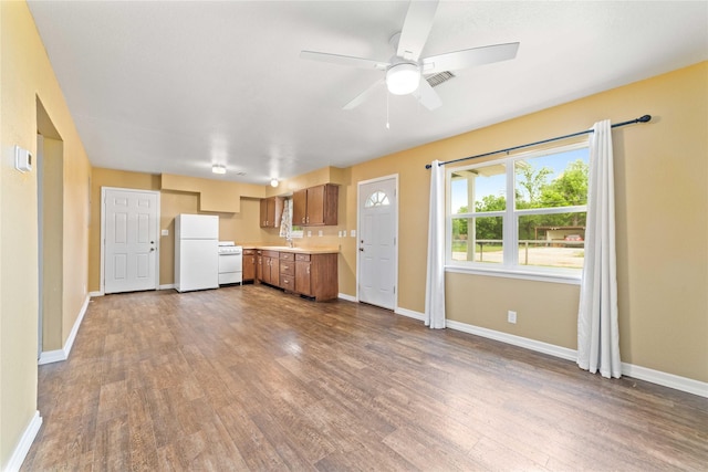kitchen with freestanding refrigerator, light countertops, dark wood finished floors, baseboards, and ceiling fan