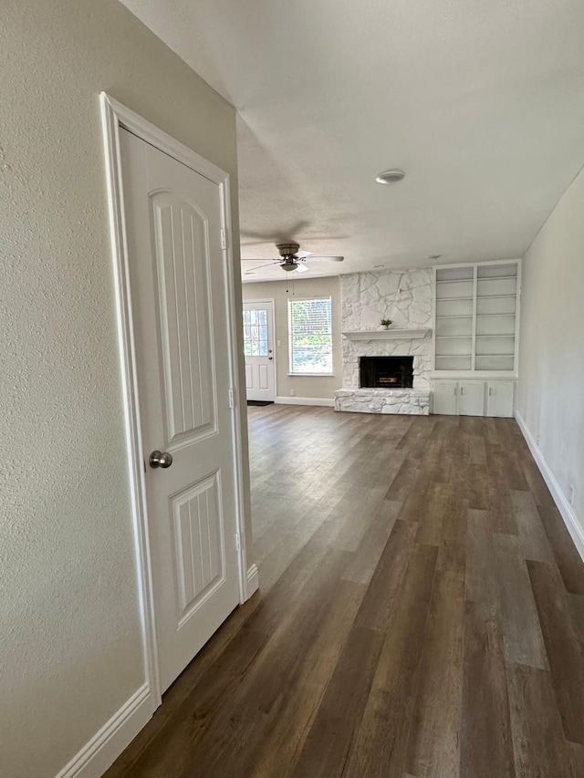 5711 Trail Lake Dr, Arlington, TX 76016 - unfurnished living room featuring dark wood-style flooring, baseboards, built in features, and a fireplace