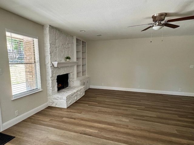 5711 Trail Lake Dr, Arlington, TX 76016 - unfurnished living room featuring ceiling fan, wood finished floors, baseboards, a fireplace, and a textured ceiling