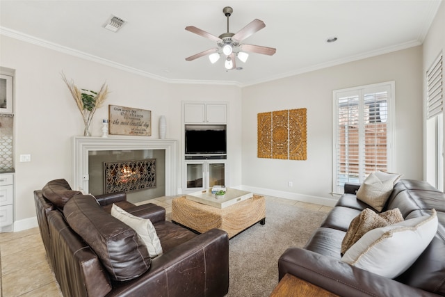 5063 Stillwater Trl, Frisco, TX 75034 - living room featuring ceiling fan, light tile patterned flooring, crown molding, a warm lit fireplace, and baseboards