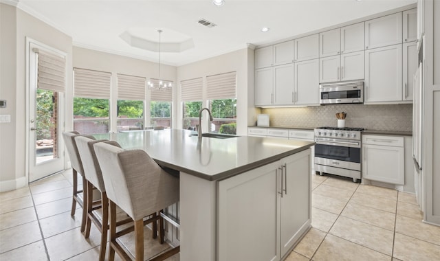 5063 Stillwater Trl, Frisco, TX 75034 - kitchen featuring appliances with stainless steel finishes, backsplash, light tile patterned floors, a sink, and a breakfast bar