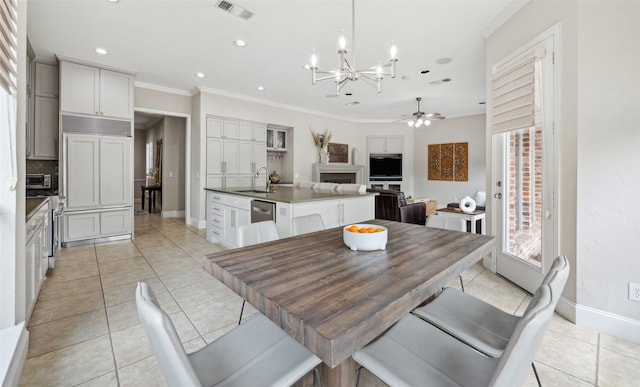 5063 Stillwater Trl, Frisco, TX 75034 - dining area with crown molding, a chandelier, baseboards, ceiling fan, and light tile patterned floors