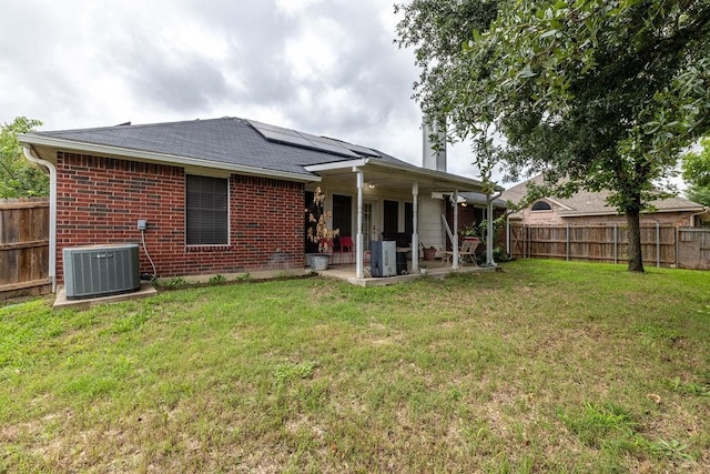 600 Hanover Dr, Waxahachie, TX 75165 - rear view of house with a patio, a fenced backyard, roof mounted solar panels, a shingled roof, and brick siding