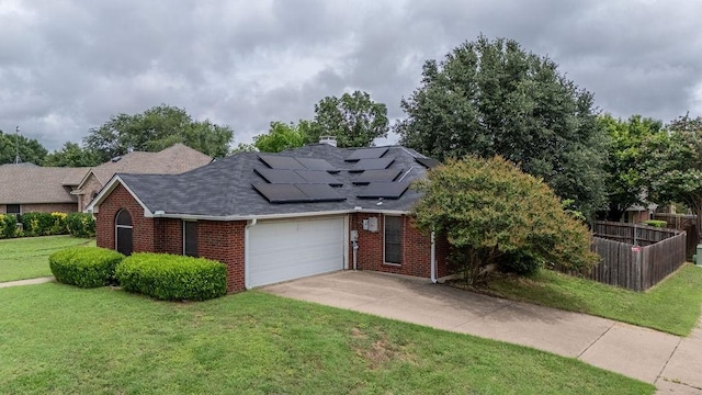 600 Hanover Dr, Waxahachie, TX 75165 - view of front facade with brick siding, roof mounted solar panels, an attached garage, concrete driveway, and a shingled roof