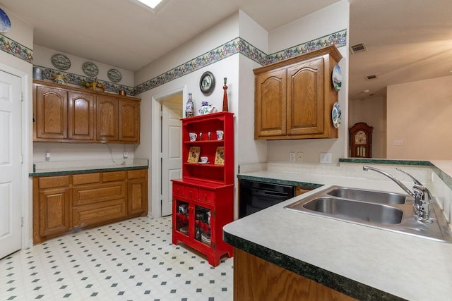 600 Hanover Dr, Waxahachie, TX 75165 - kitchen featuring dishwasher, brown cabinets, light flooring, and a peninsula