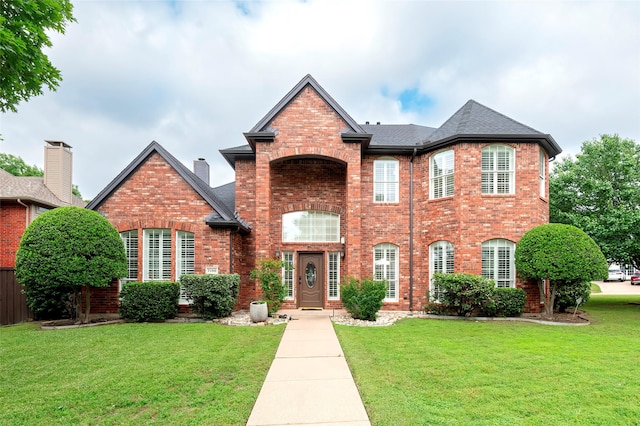 7100 Oakbrook Dr, Plano, TX 75025 - view of front facade featuring brick siding, a front yard, and a shingled roof