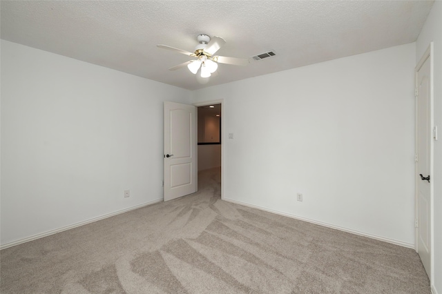7100 Oakbrook Dr, Plano, TX 75025 - empty room featuring a ceiling fan, light colored carpet, a textured ceiling, and baseboards