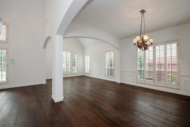 7100 Oakbrook Dr, Plano, TX 75025 - unfurnished dining area featuring a chandelier, ornamental molding, dark wood-style floors, arched walkways, and wainscoting