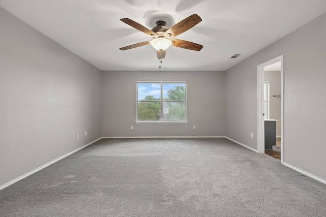 spare room featuring a ceiling fan, carpet, and baseboards