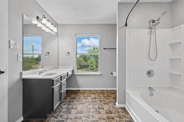 full bathroom with healthy amount of natural light, vanity, shower / bath combination, and baseboards