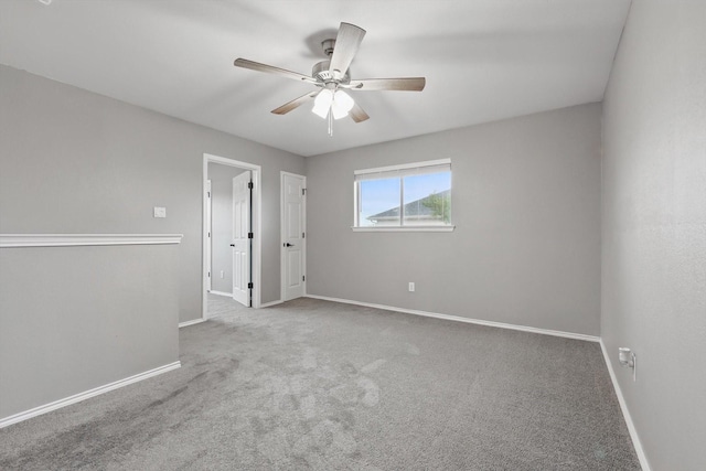 spare room featuring baseboards, carpet flooring, and a ceiling fan
