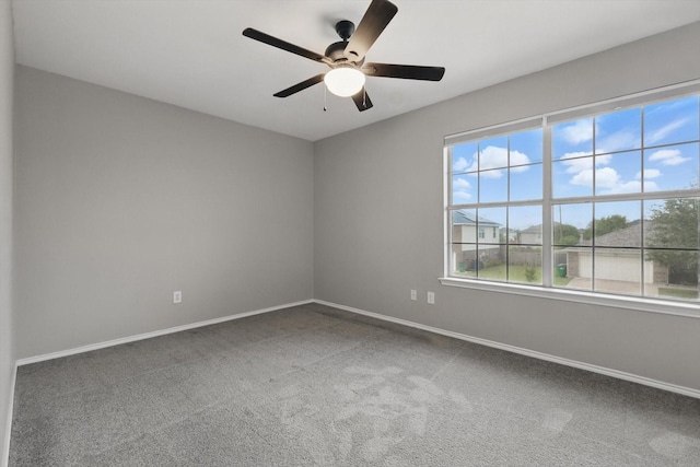 carpeted spare room with baseboards and ceiling fan