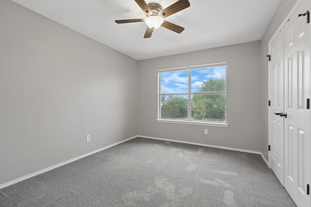 unfurnished bedroom with a closet, carpet flooring, baseboards, and a ceiling fan