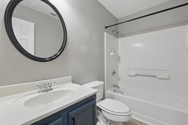 bathroom featuring toilet, vanity, shower / bathtub combination, and a textured wall