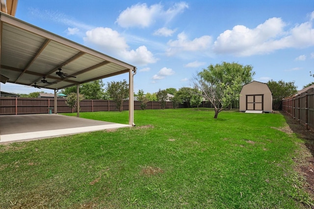view of yard with a patio area, a storage shed, ceiling fan, and an outbuilding
