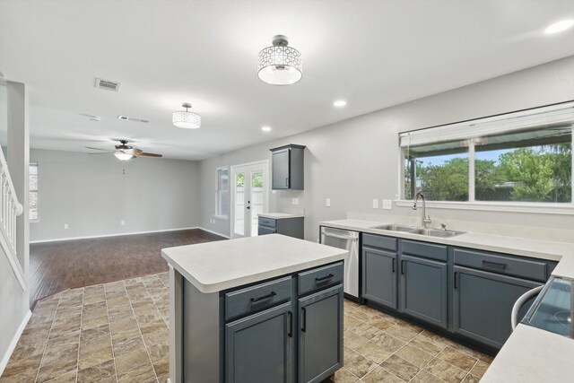 kitchen featuring a sink, dishwasher, ceiling fan, light countertops, and healthy amount of natural light