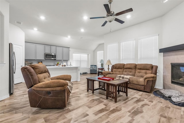 7225 Tesoro Trl, Fort Worth, TX 76131 - living area with lofted ceiling, a ceiling fan, light wood-style flooring, recessed lighting, and a tiled fireplace