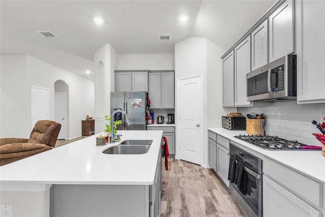 7225 Tesoro Trl, Fort Worth, TX 76131 - kitchen featuring stainless steel appliances, a sink, gray cabinets, arched walkways, and recessed lighting