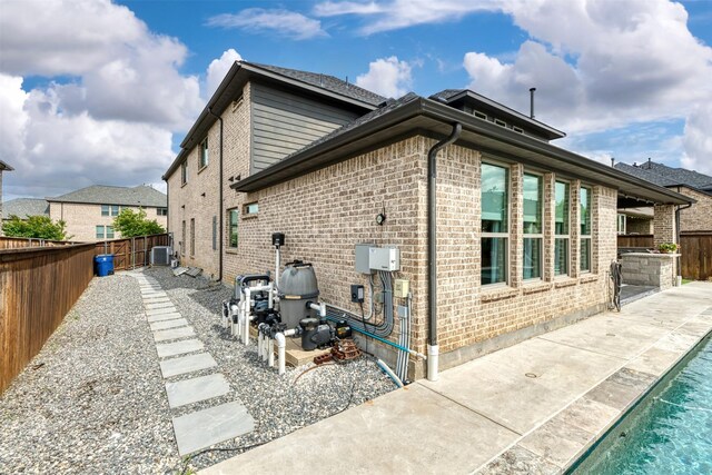16175 Barton Creek Ln, Frisco, TX 75033 - view of home's exterior with a patio area, a fenced backyard, and brick siding