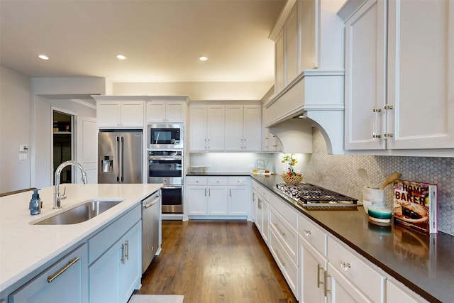 16175 Barton Creek Ln, Frisco, TX 75033 - kitchen with a sink, appliances with stainless steel finishes, white cabinetry, dark wood-style flooring, and tasteful backsplash
