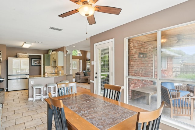 dining space featuring a ceiling fan and light tile patterned floors