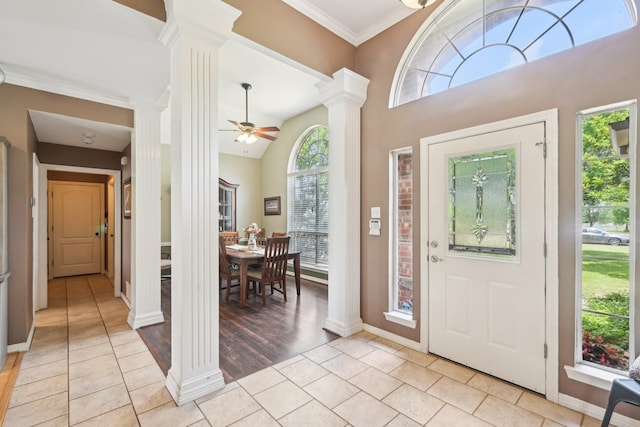 entryway featuring decorative columns, a ceiling fan, light tile patterned flooring, ornamental molding, and baseboards
