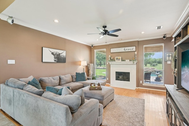 living area with healthy amount of natural light, crown molding, ceiling fan, light wood-style floors, and recessed lighting