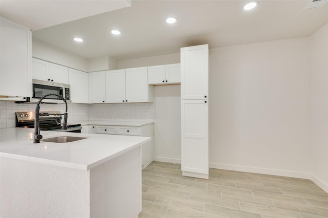 22 W Mountain Ln Unit 42, Grand Prairie, TX 75052 - kitchen with stainless steel appliances, backsplash, light countertops, white cabinetry, and recessed lighting
