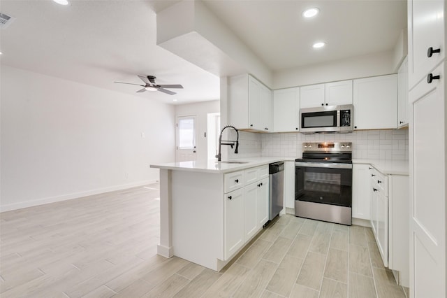 22 W Mountain Ln Unit 42, Grand Prairie, TX 75052 - kitchen with stainless steel appliances, a sink, a peninsula, a ceiling fan, and backsplash