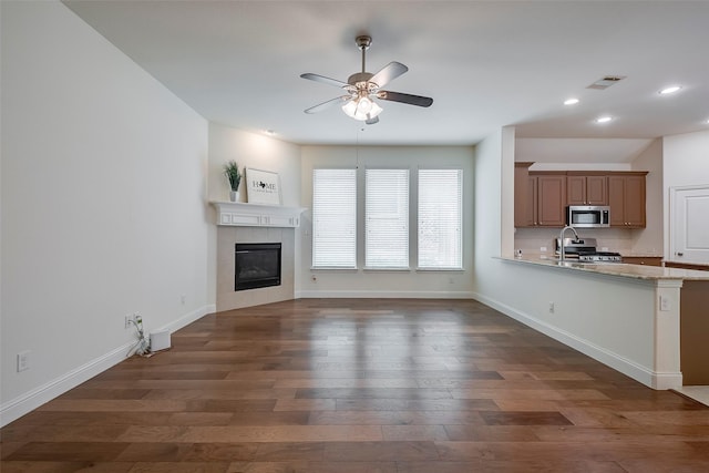 15429 Pioneer Bluff Trl, Fort Worth, TX 76262 - unfurnished living room featuring a ceiling fan, recessed lighting, dark wood-type flooring, a tiled fireplace, and baseboards