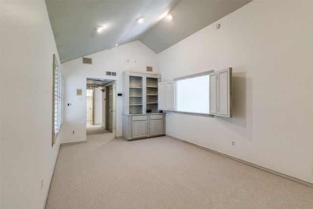 unfurnished bedroom with light colored carpet and high vaulted ceiling