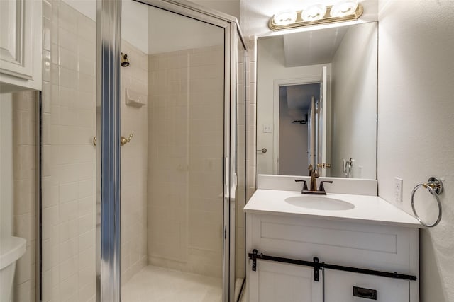 bathroom featuring a shower stall, vanity, and toilet