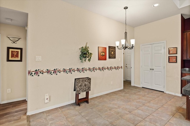 empty room with a chandelier, baseboards, and recessed lighting