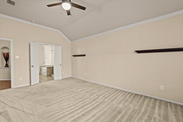 unfurnished bedroom featuring carpet floors, ornamental molding, lofted ceiling, baseboards, and connected bathroom