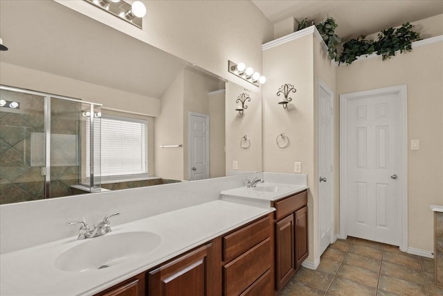 full bath featuring a stall shower, double vanity, and baseboards