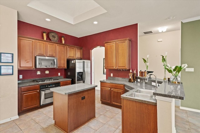 kitchen featuring appliances with stainless steel finishes, a sink, a peninsula, a center island, and light tile patterned flooring