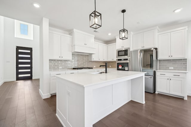 4190 Holland Ct, Prosper, TX 75078 - kitchen with appliances with stainless steel finishes, a sink, a center island with sink, white cabinetry, and light countertops