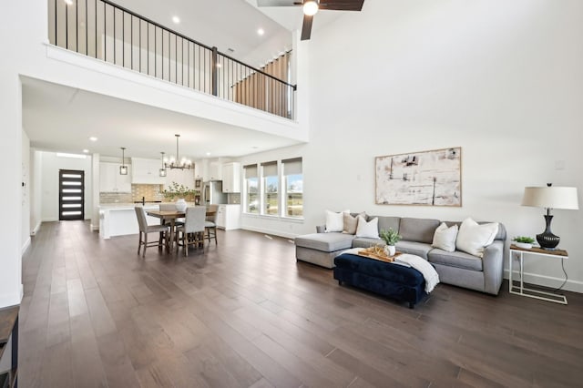 4190 Holland Ct, Prosper, TX 75078 - living room featuring a chandelier, dark wood-style flooring, a towering ceiling, baseboards, and recessed lighting