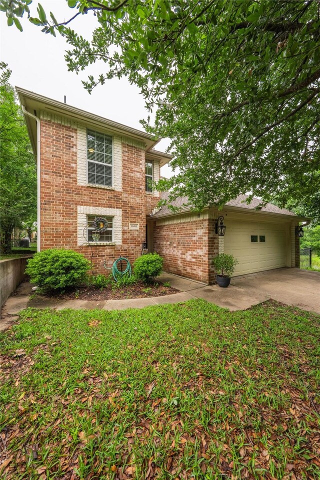 traditional home with brick siding, concrete driveway, and a garage