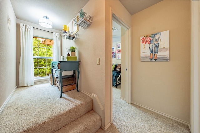 hall featuring carpet and baseboards
