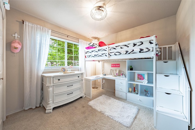 bedroom with light colored carpet and a desk