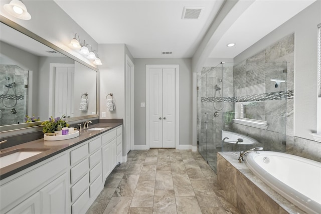 full bathroom featuring a stall shower, a garden tub, double vanity, and baseboards