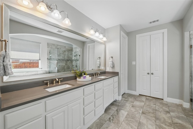 full bathroom with a shower stall, baseboards, and double vanity