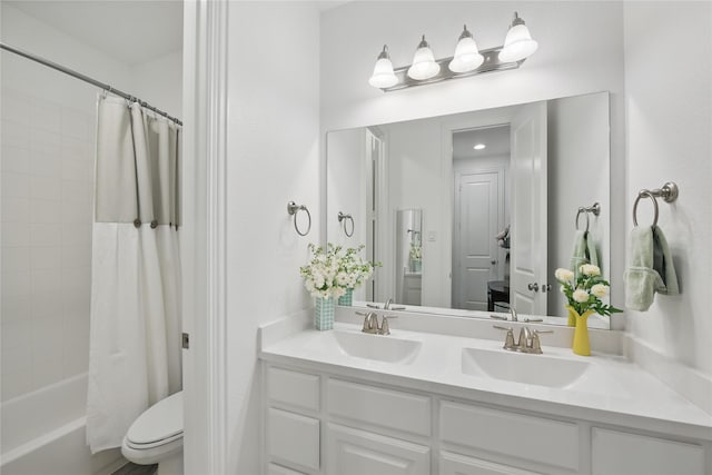 bathroom featuring toilet, double vanity, and shower / bath combo